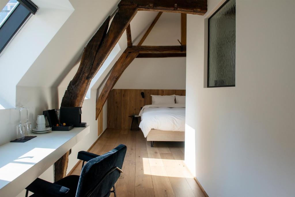 安特卫普Hotel Riga的卧室配有一张床、一张桌子和椅子
