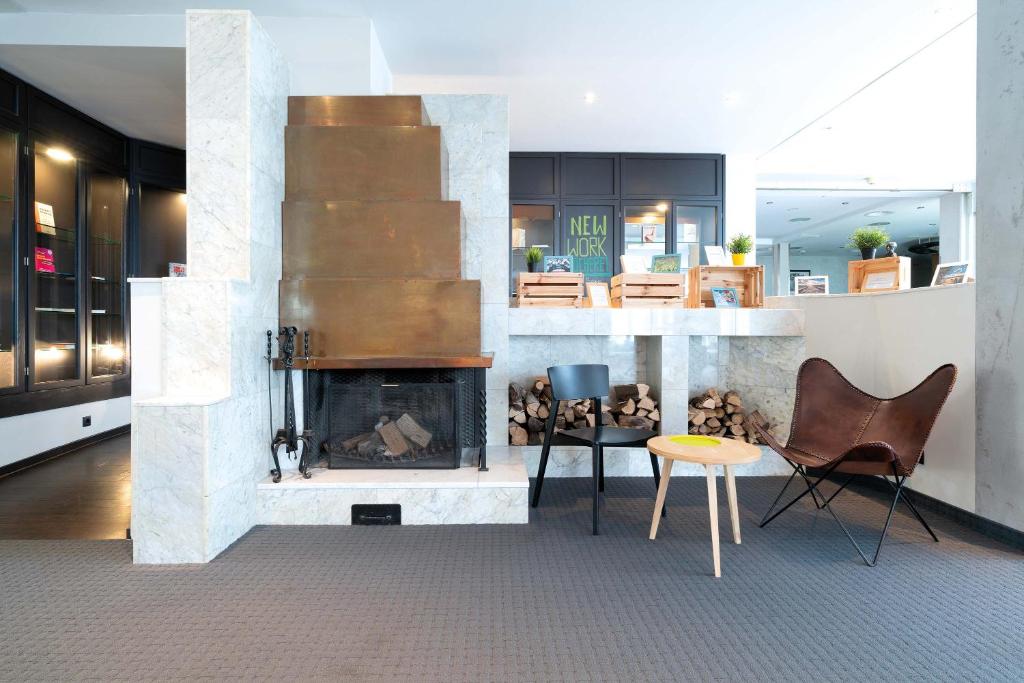 巴特洪内夫塞米那里斯巴特洪内夫酒店的客厅设有壁炉、桌子和椅子
