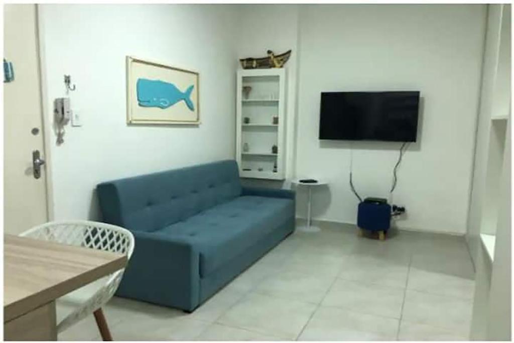 桑托斯Apto com Wi-Fi bem perto da praia em Santos SP的客厅配有蓝色的沙发和电视