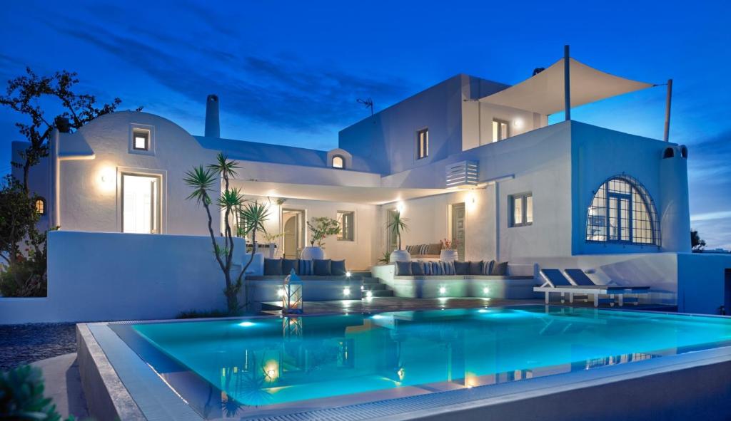 梅萨雷亚Aleria Villa Santorini的夜间带游泳池的别墅