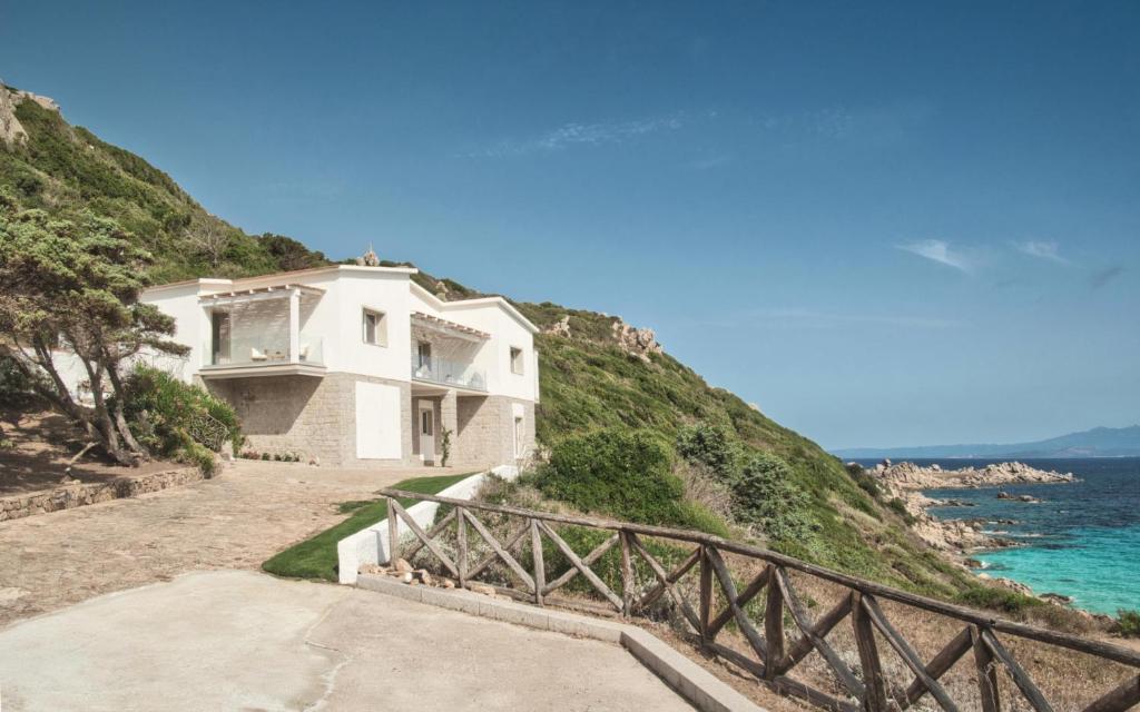 圣特雷莎加卢拉Villa Bianca Luxury B&B Experience的海边小山上的白色房子