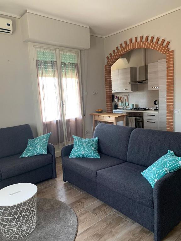 蒂勒尼亚Casina Summer的一间带蓝色沙发的客厅和一间厨房