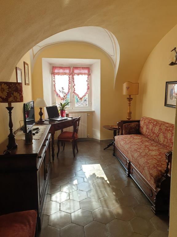 奥瓦达La Foresteria del Passeggere的客厅配有沙发和带笔记本电脑的书桌