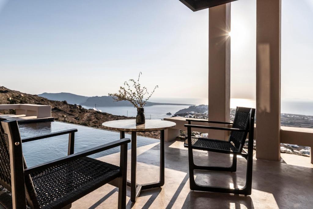 伊亚Nimbus Santorini的海景阳台上的桌椅
