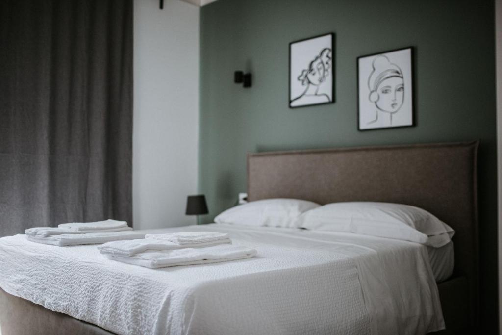 阿布鲁齐的罗塞托L'Anfora Residence的卧室配有白色的床和2条毛巾
