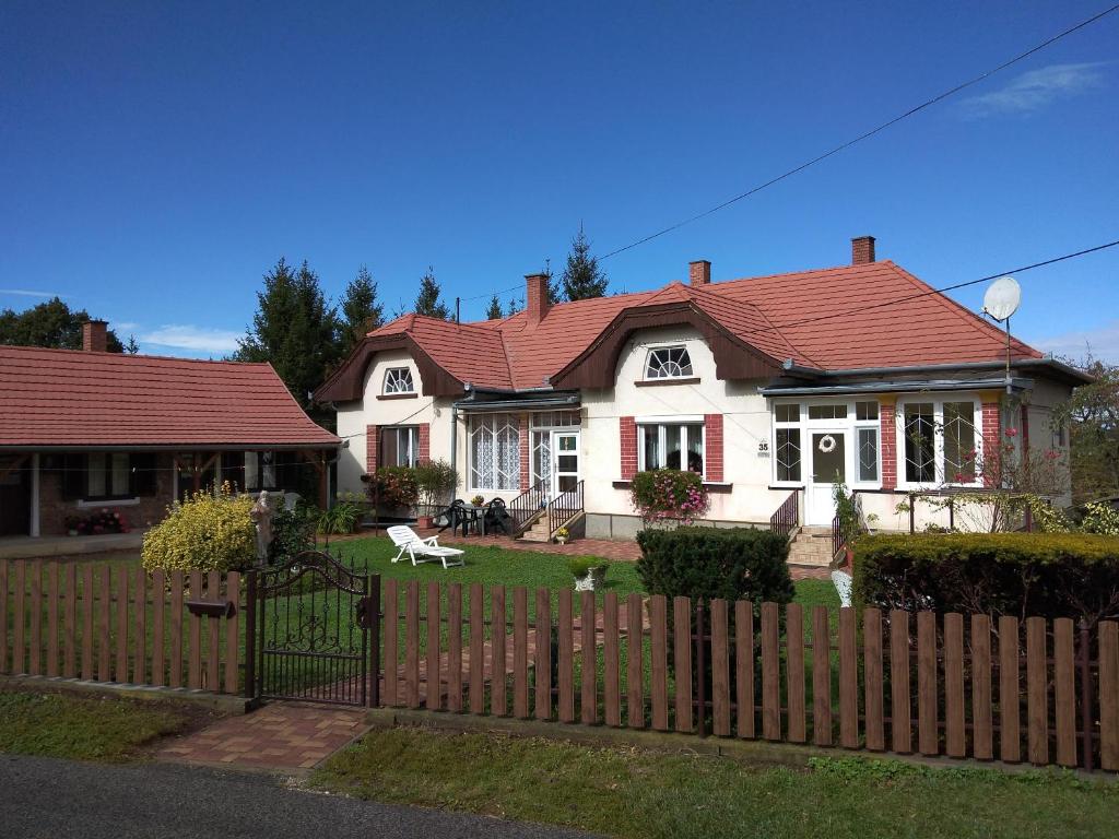 NagyrákosŐrségi Gorza Vendégház的白色的房子,有红色的屋顶和栅栏