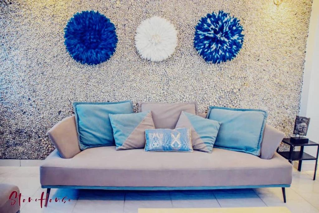 杜阿拉Stone House - Makepe, Douala的客厅配有带蓝色枕头的沙发