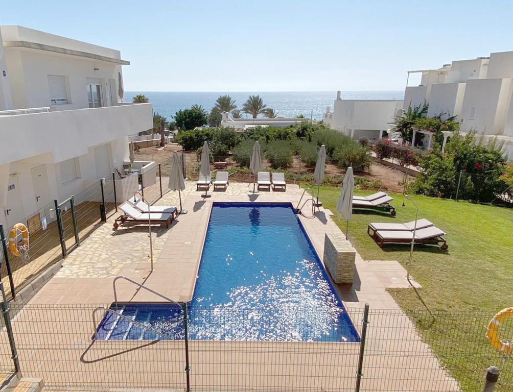 莫哈卡尔Mda Playa del Cantal的一个带椅子的游泳池,背景是大海