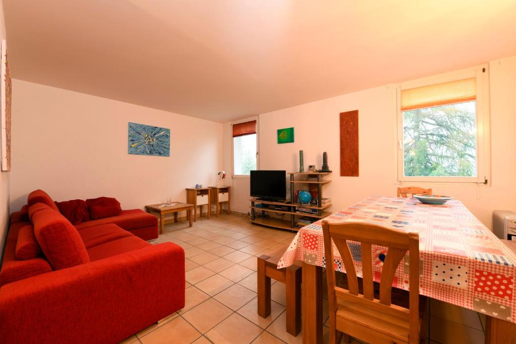 博斯克古林Bosco Gurin Nature & Ski的客厅配有红色的沙发和桌子