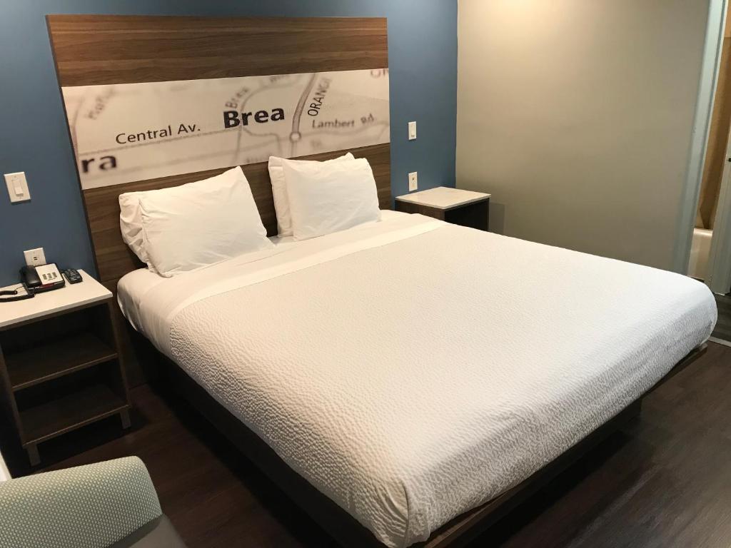 布雷亚布雷亚海兰汽车旅馆的卧室配有一张带白色床单和枕头的大床。