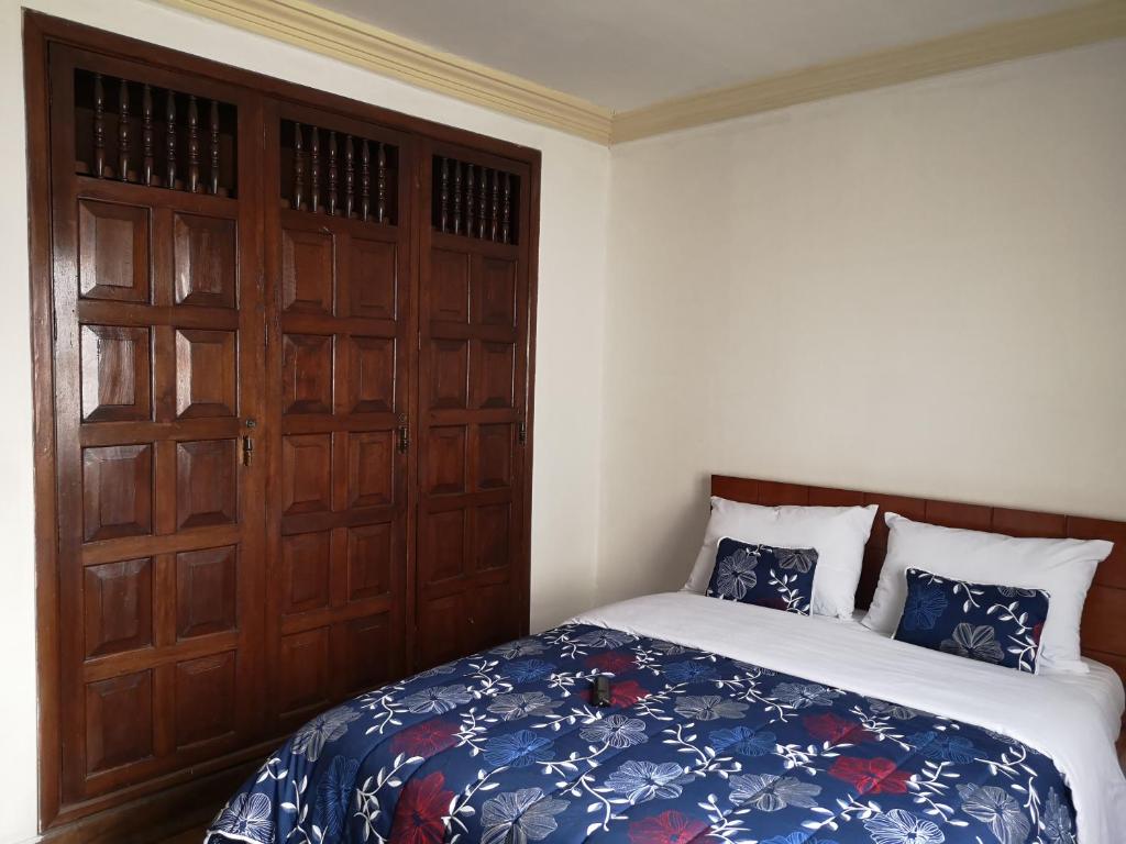 波帕扬Hotel Lili - Popayán的一间卧室配有一张床和一扇木门