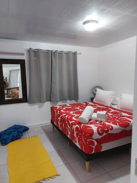 帕皮提BUNGALOW PAMATAI的卧室配有红色和白色的床和镜子