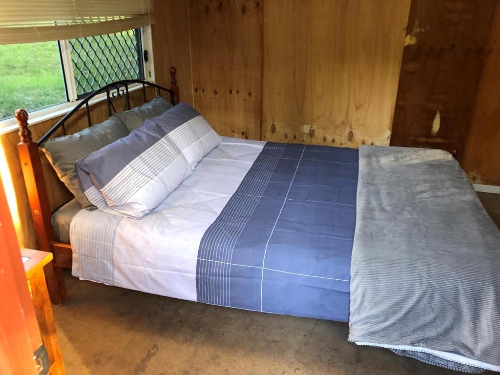 TabulamEmu Creek Retreat的蓝色棉被的床上