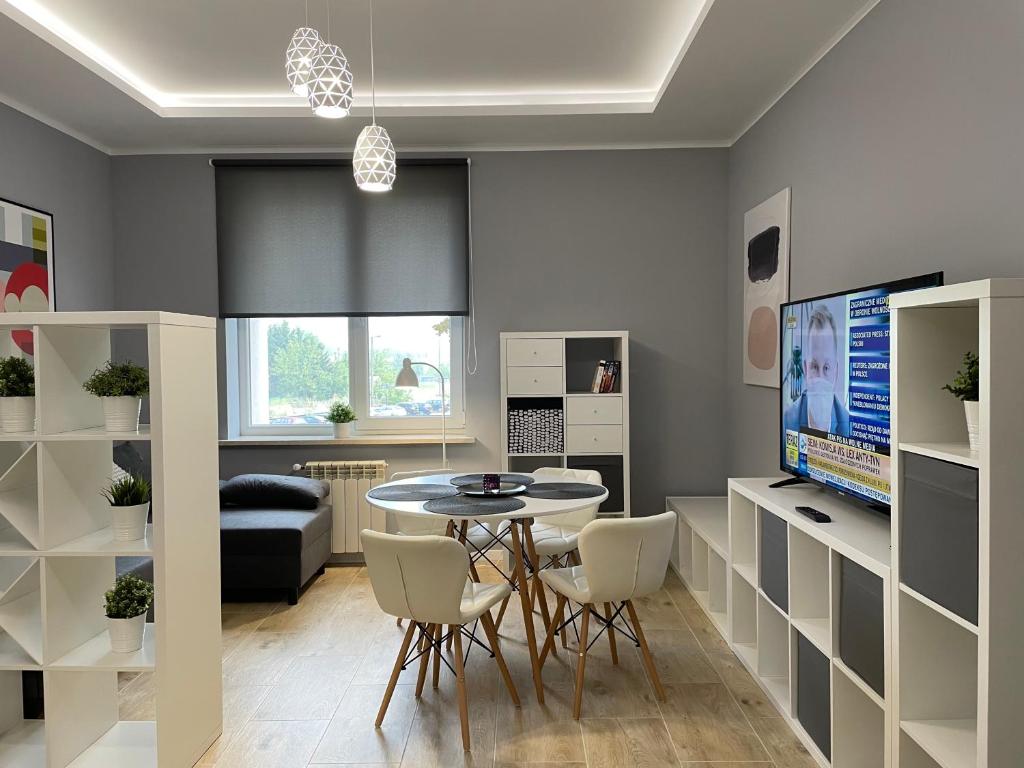 比亚韦斯托克Apartament BERLIN的客厅配有桌椅和电视。