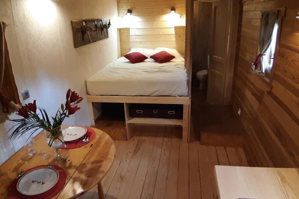 JaujacCharmante Roulotte atypique的小房间设有一张床和一张桌子
