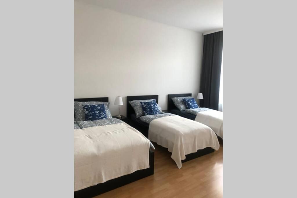维也纳Wohnung in Wien的配有白色墙壁和木地板的客房内的两张床