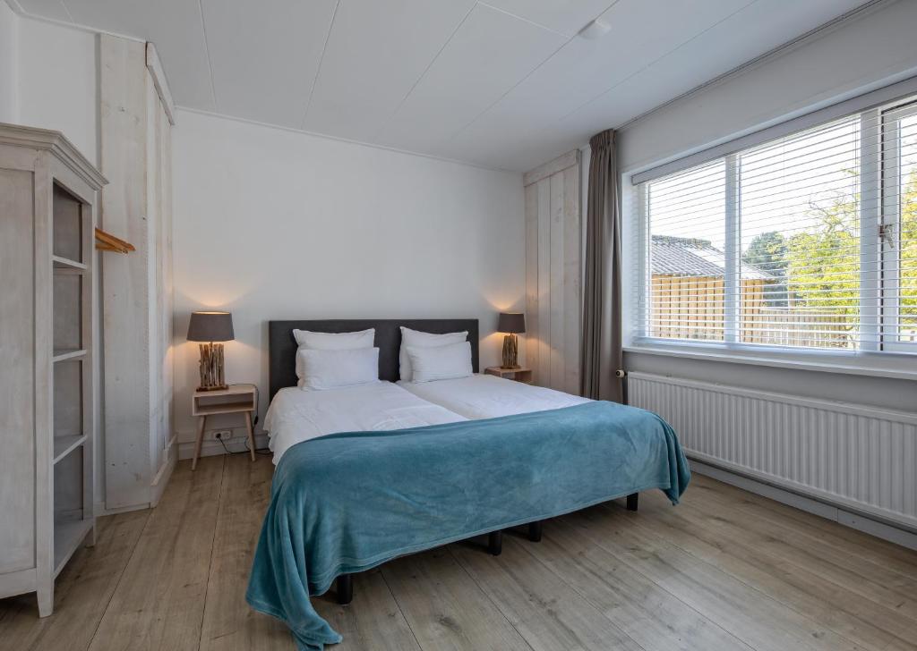 德科克斯多普Zilt Texel的一间卧室设有一张大床和一个大窗户