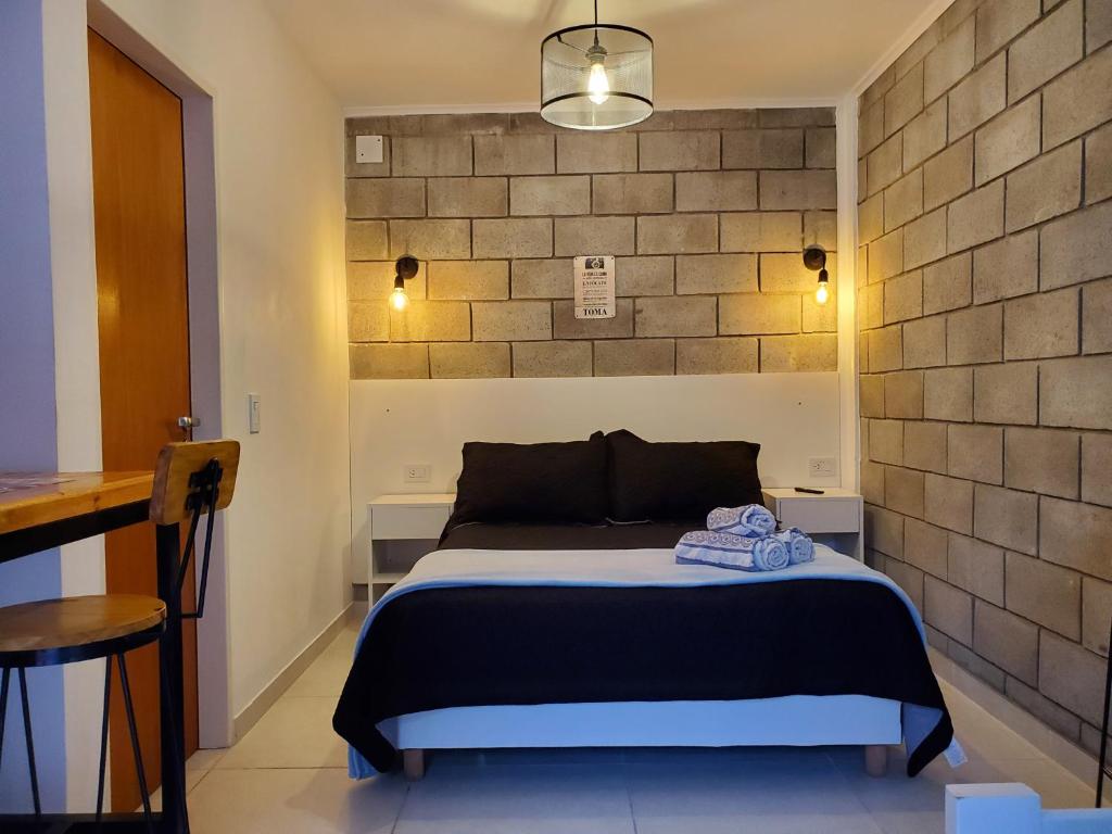 蒙特格兰德Suite NY, depto a estrenar -15 min Aerop的一间卧室设有一张床和砖墙