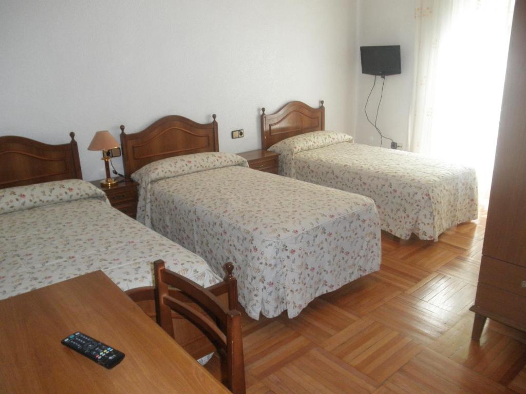 马德里洛斯安第斯旅馆的酒店客房设有三张床和一张桌子