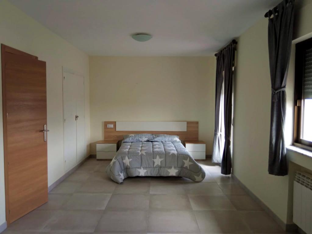 下卡尔瓦拉萨La Villa Hostal的卧室位于客房的角落,配有一张床
