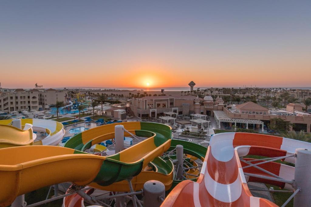 赫尔格达Pickalbatros Aqua Park Resort - Hurghada的日落时分在水上公园的一组滑梯