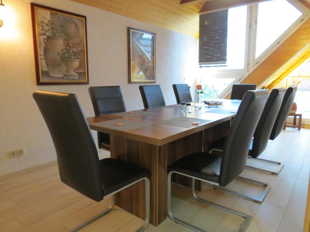 森夫滕贝格Penthouse Wolkenstein großzügige Maisonette auf 155 qm mit Whirlpool, Klima & Kamin的一间会议室,配有木桌和黑椅子
