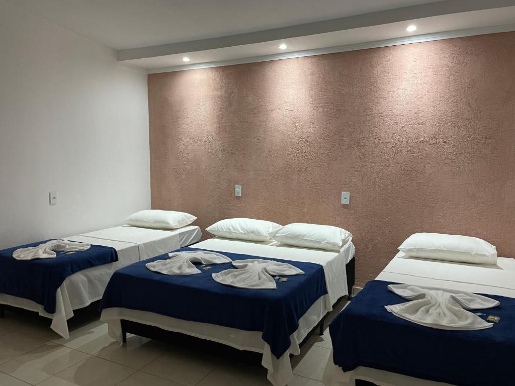 卡皮托利乌Pousada Império de Minas的客房内的三张床和毛巾