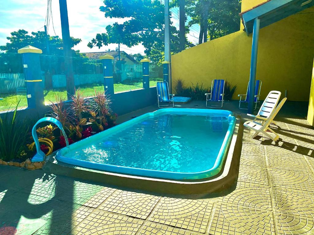 巴拉那州蓬塔尔Refúgio aconchegante com vista para o mar!的院子里的游泳池周围设有椅子