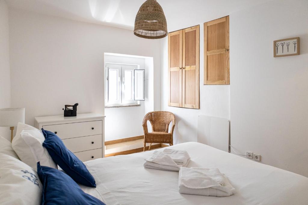 维迪堡Casa da Judiaria的卧室配有白色的床和椅子