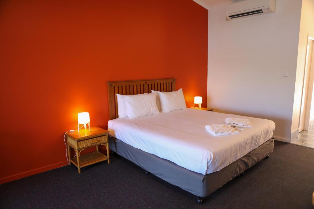 Lake BennettDe Lago Resort On Lake Bennett的一间卧室配有一张带橙色墙壁的大床