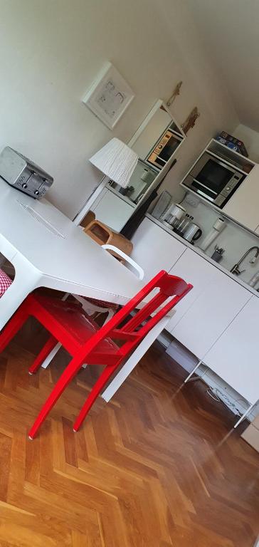 马尔默Cityclose for five Malmö的白色桌子上的一个红色椅子