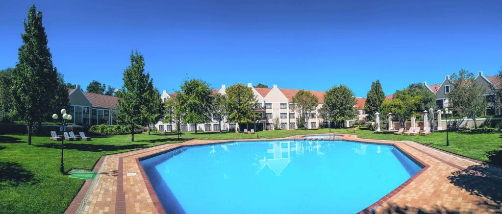 布隆方丹Southern Sun Bloemfontein的一座房子的院子内的大型游泳池