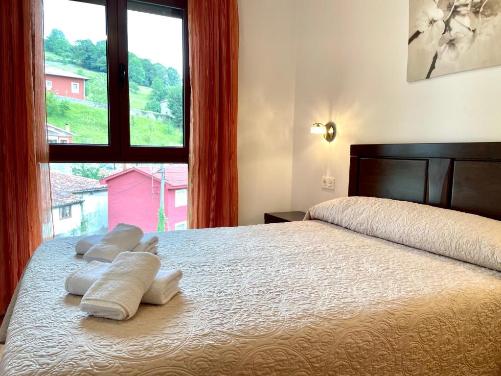 卡瑞纳Piso San Andrés - Picos de Europa的一间卧室设有一张大床和窗户