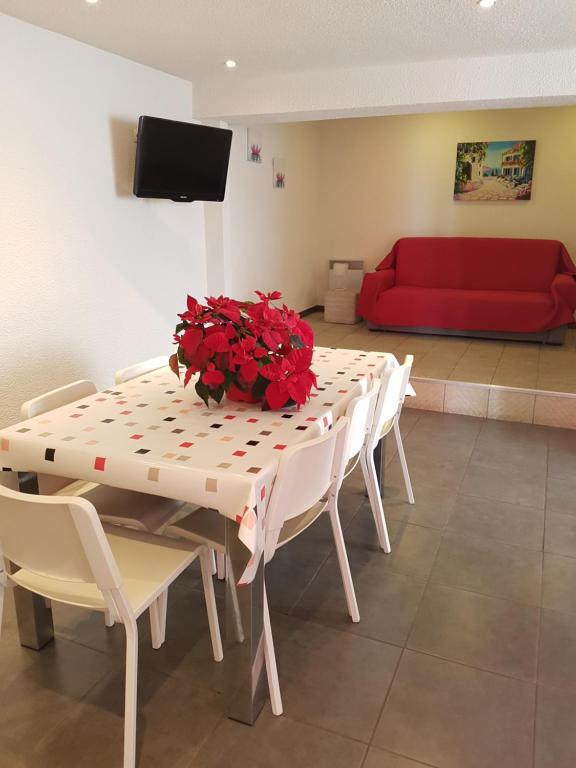卢尔德圣利玛窦公寓的一张红色花的桌子和红色沙发
