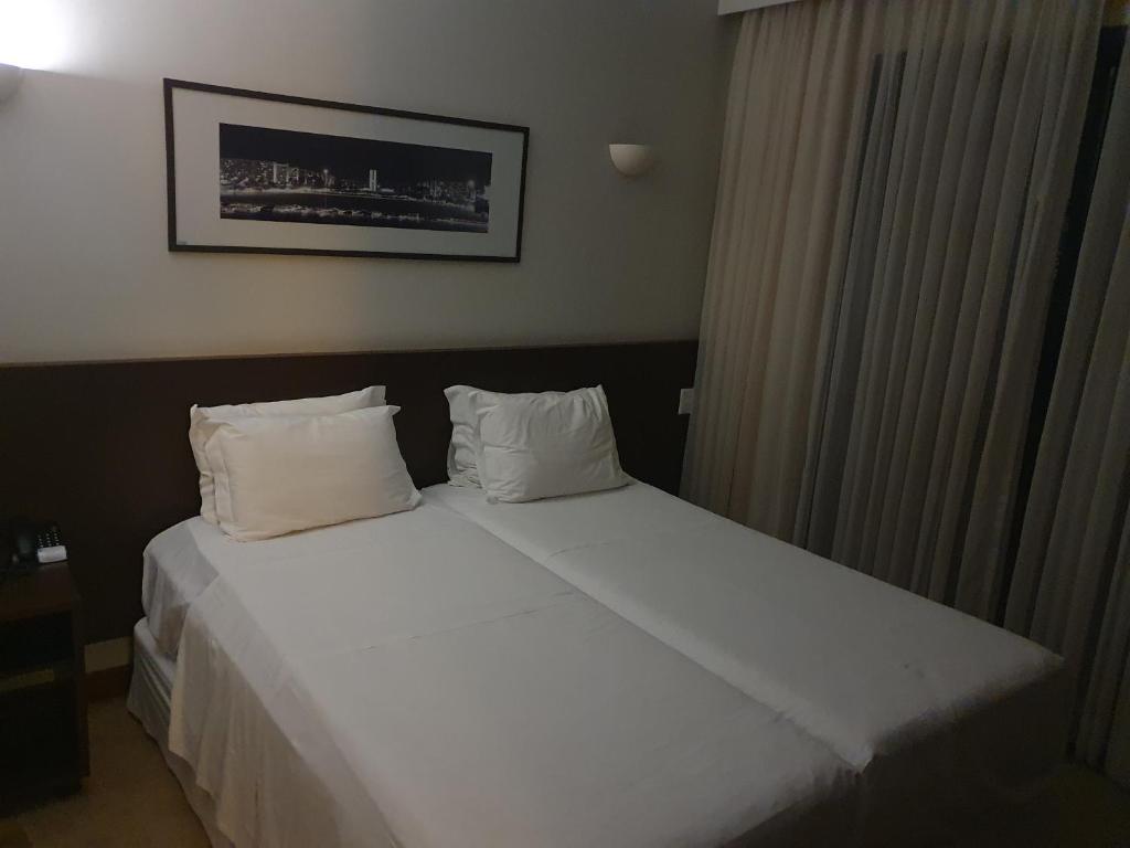 巴西利亚Hotel Bonaparte Blue Residence F 209的一张大白色的床,位于酒店客房内