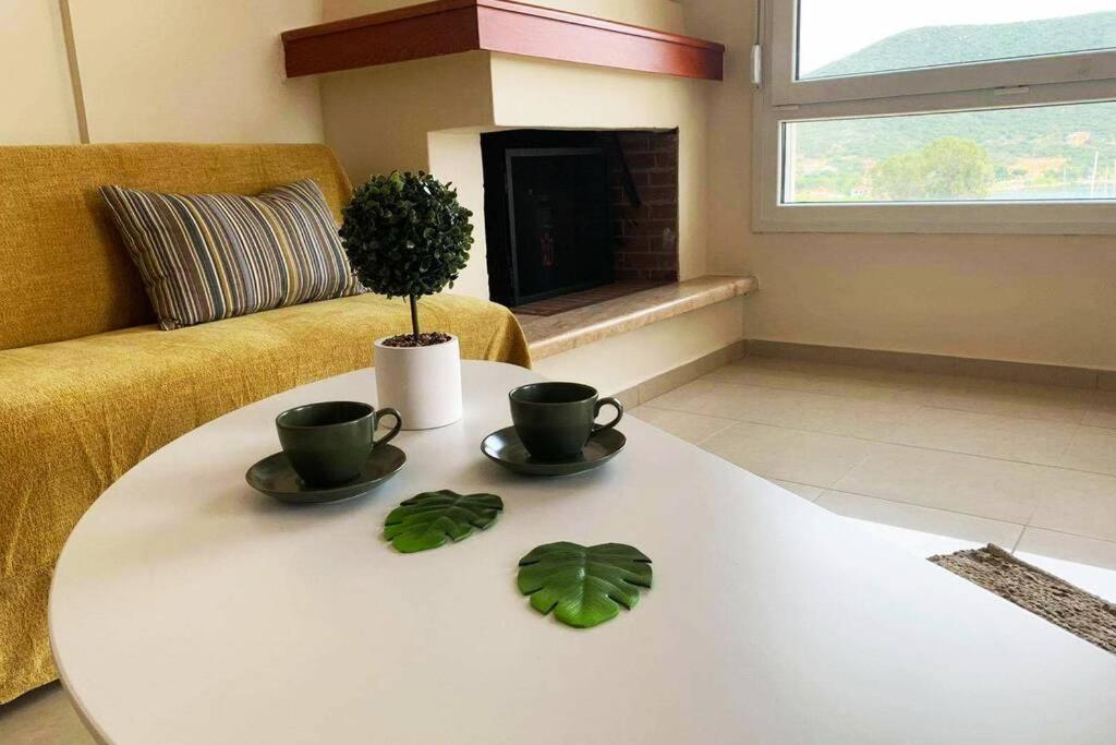 尼亚普拉莫斯Port View House-Comfy Family Apartment-Panoramic View的客厅,配有桌子,配上两杯和一株植物