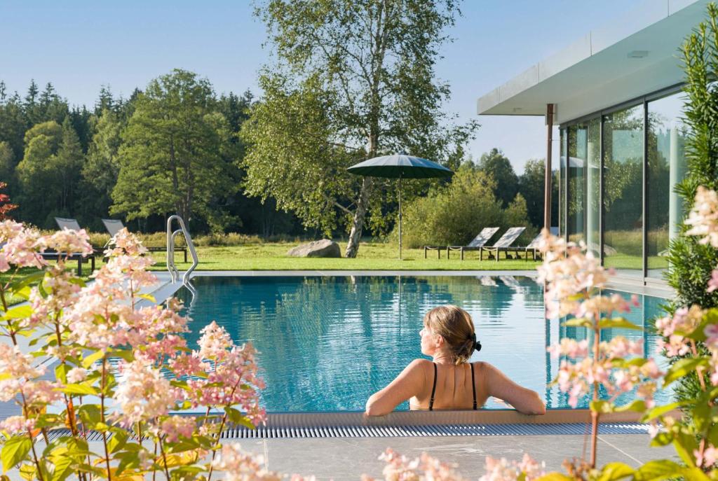 欣特察尔滕托马霍夫酒店的一名妇女在度假村的游泳池里