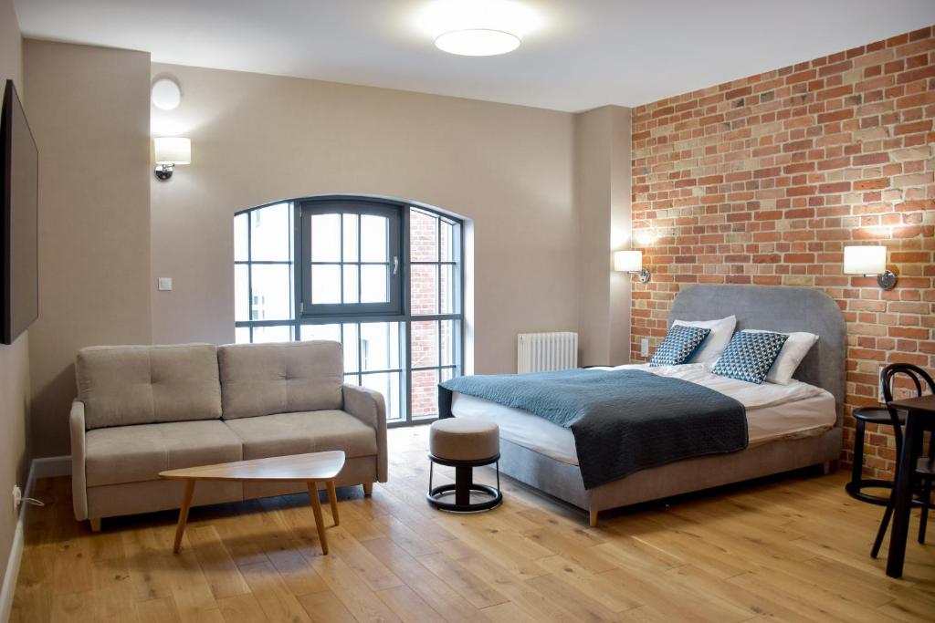 格但斯克Apartamenty Nowy Browar Gdański的一间卧室配有一张床和一张沙发
