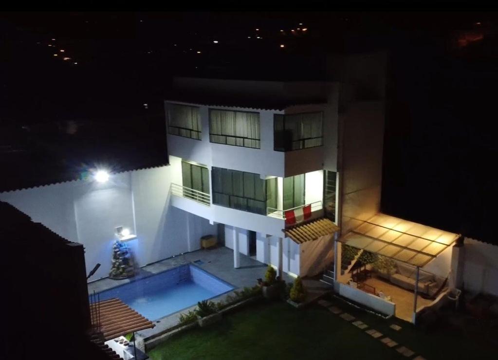 安达韦拉斯Villa blanca的一座白色的大建筑,晚上设有游泳池