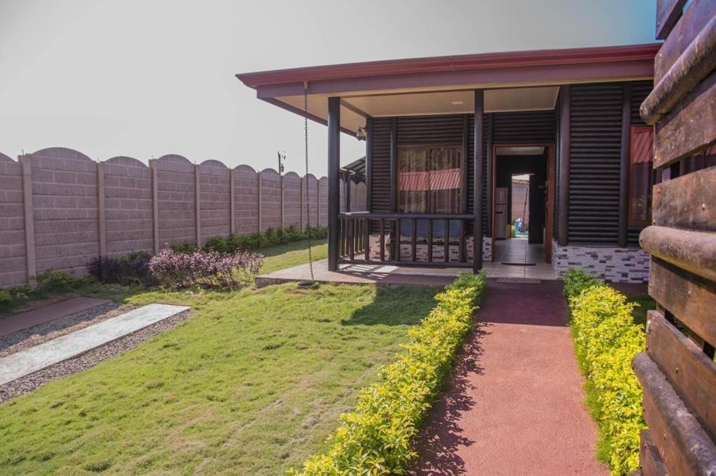 福尔图纳Cabaña El Monasterio的一座房子,旁边是草地庭院