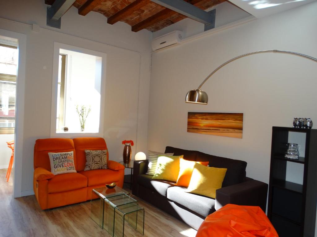 巴塞罗那桑茨之感公寓的客厅配有橙色沙发和黄色枕头。