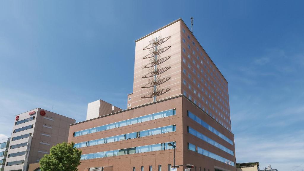 福岛福岛桑科约酒店的一座高大的建筑,背后是蓝天
