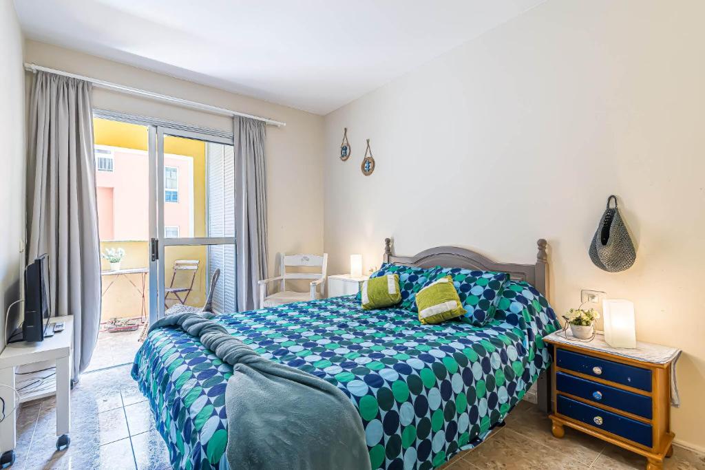 厄尔梅达诺Alquilaencanarias-El Medano Delfines-2 rooms的一间卧室配有一张带蓝色和白色棉被的床