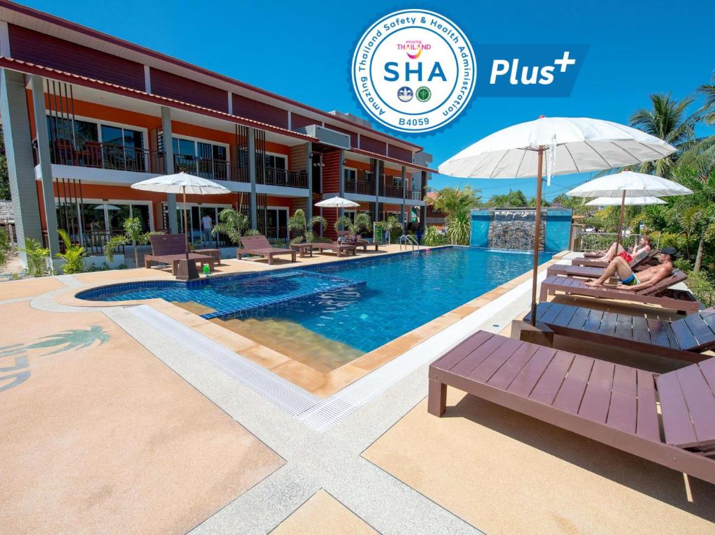 高兰Hatzanda Lanta Resort - SHA Extra Plus的一座游泳池,有两人坐在长椅上