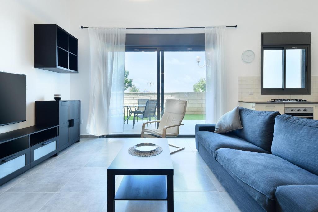 纳哈里亚Luxury Living at Achziv Beach Apartment by Sea N' Rent的客厅配有蓝色的沙发和桌子