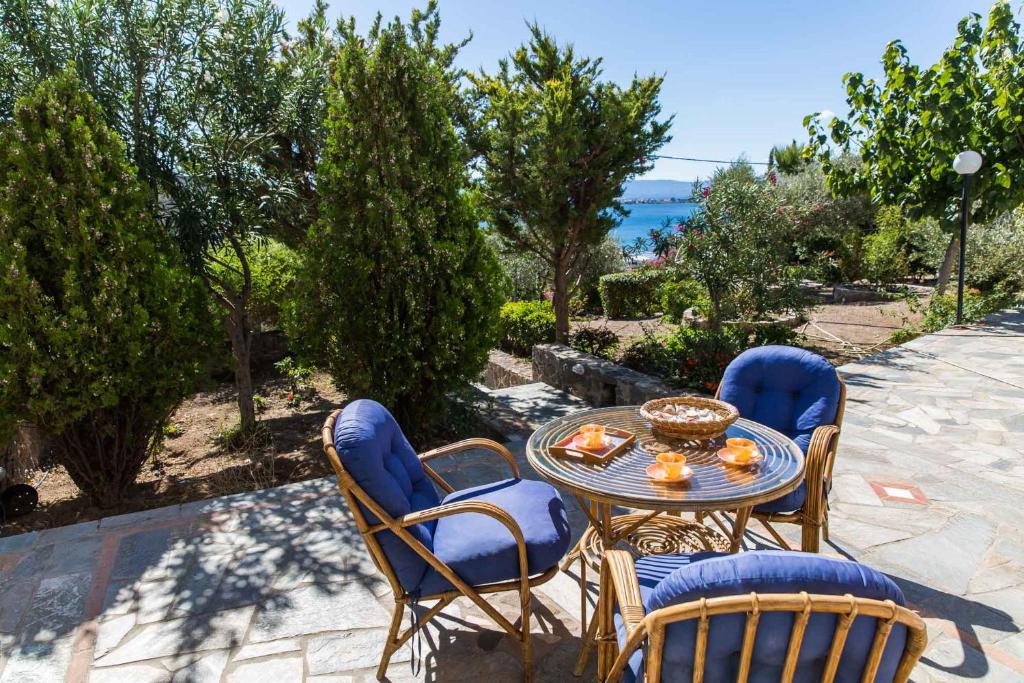 爱琴娜岛Villa Euphoria Studio in Aegina, A' Marathonas Bay的一个带桌椅的庭院和大海