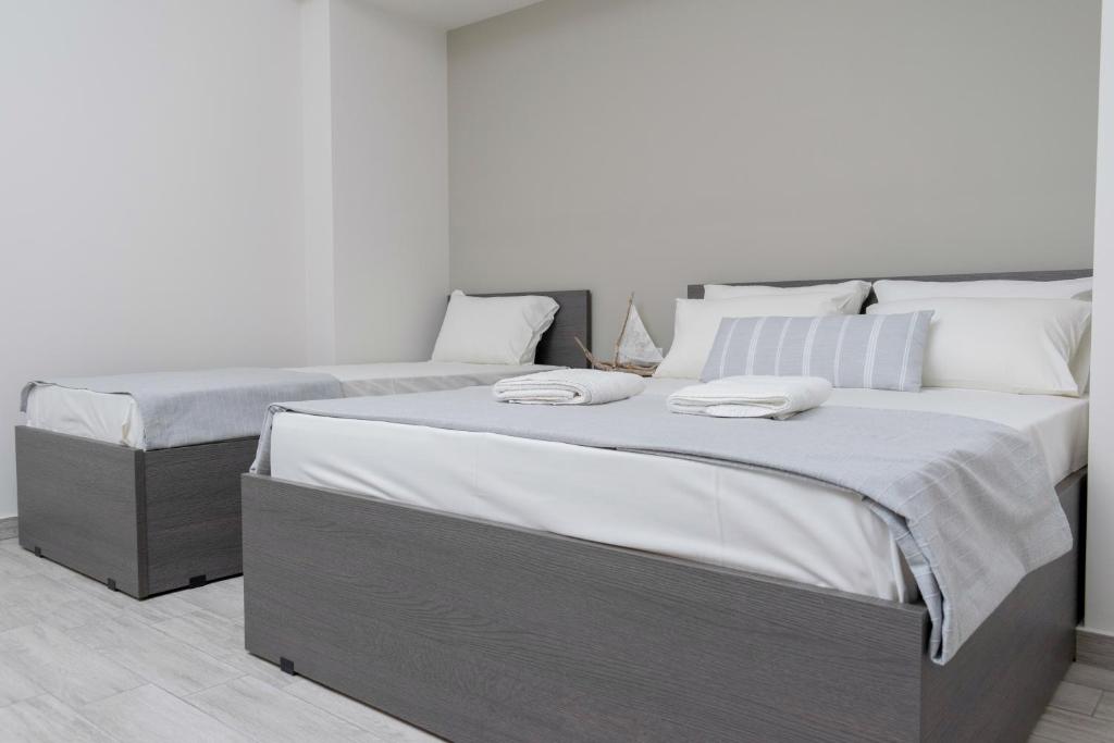 奥林匹亚基·阿克蒂Casa Di Mare II的一间卧室配有两张带白色床单和枕头的床。