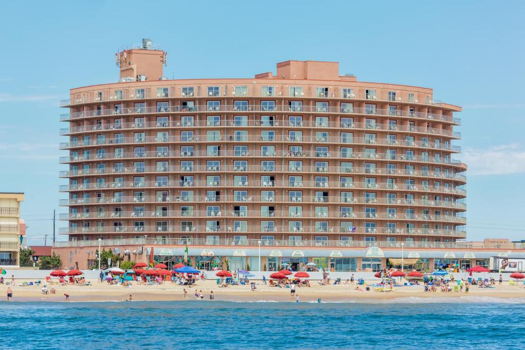 大洋城Grand Hotel Ocean City Oceanfront的海滩上一座大型建筑,上面有带遮阳伞的海滩