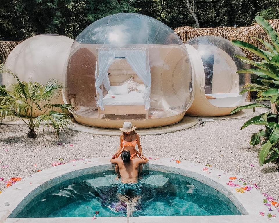 诺萨拉Nosara Satori Bubbles的坐在圆顶屋游泳池中的女人