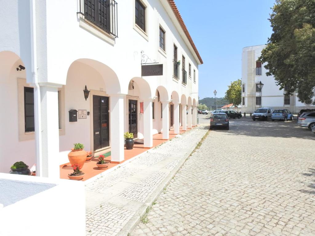 奥比多斯Hospedaria Do Senhor da Pedra的白色建筑前的鹅卵石街道